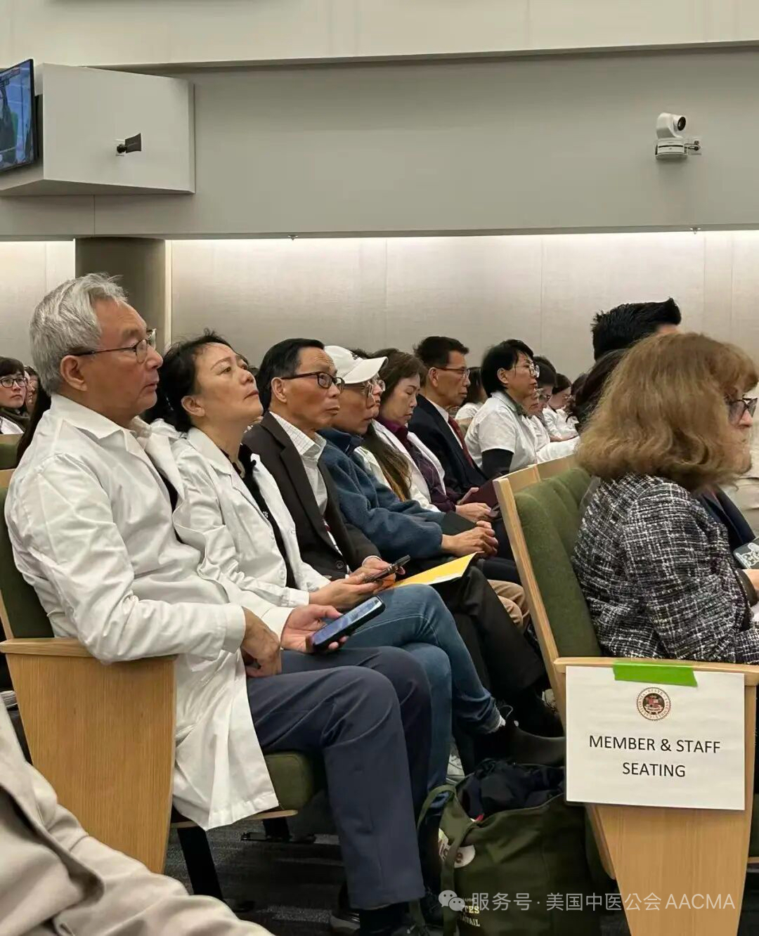 Practitioners in white coats at the hearing